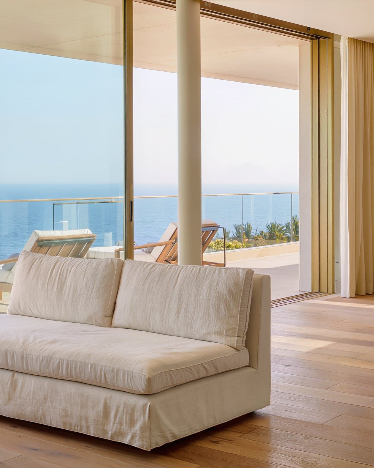 Bright living room with a linen sofa and a terrace overlooking the sea